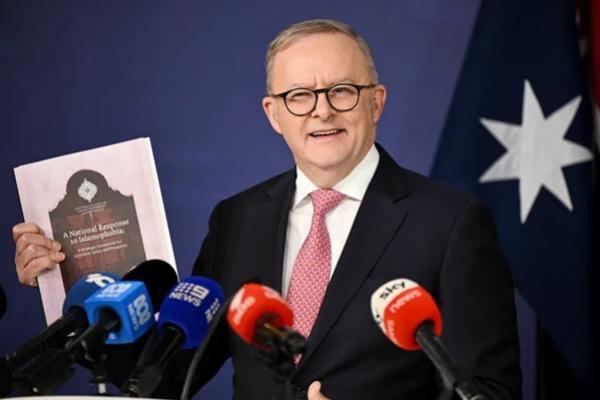 Perdana Menteri Australia Anthony Albanese memegang salinan laporan Tanggapan Nasional terhadap Islamofobia saat berbicara kepada media dalam konferensi pers di Kantor Parlemen Persemakmuran di Sydney pada 12 September 2025 (FOTO: AP) 