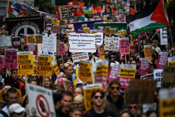 Anggota kelompok kampanye, Stand Up to Racism, berdemonstrasi menentang unjuk rasa yang diselenggarakan oleh aktivis anti-imigrasi Inggris Stephen Yaxley-Lennon, yang juga dikenal sebagai Tommy Robinson, di London, Inggris, 13 September 2025. REUTERS 