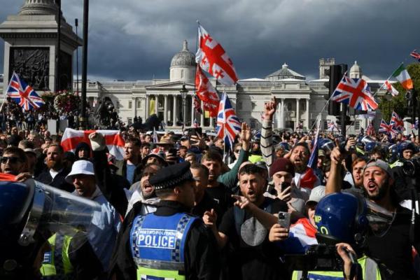 Petugas polisi berhadapan dengan pendukung aktivis anti-imigrasi Inggris Stephen Yaxley-Lennon, yang juga dikenal sebagai Tommy Robinson, selama demonstrasi di London, Inggris, 13 September 2025. REUTERS 