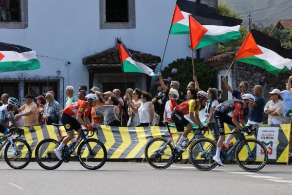 Para pebalap melewati para pengunjuk rasa dengan bendera Palestina selama etape 13 Vuelta a Espana di Cantabria, Spanyol, 5 September 2025. REUTERS 