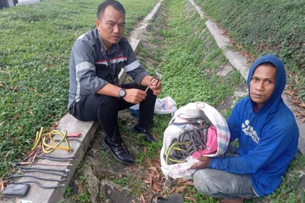 Pencuri kabel gorunding (kanan) dengan barang hasil curiannya. Foto: kcic/katakini 