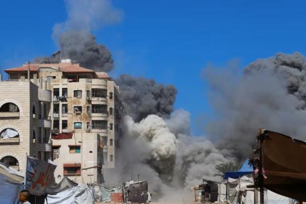 Asap mengepul dari sebuah bangunan tempat tinggal yang dievakuasi yang menampung warga Palestina yang mengungsi, di Kota Gaza, 14 September 2025. REUTERS 
