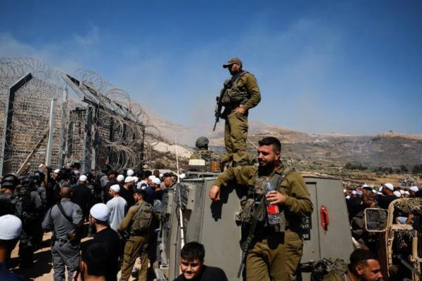 Anggota pasukan keamanan Israel berdiri di garis gencatan senjata antara Dataran Tinggi Golan yang diduduki Israel dan Suriah, 16 Juli 2025. REUTERS 
