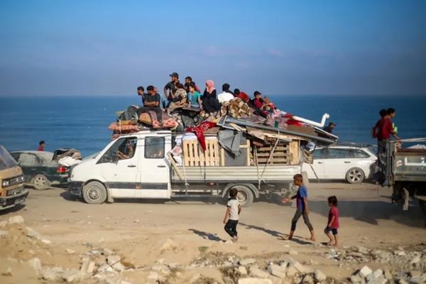 Warga Palestina yang mengungsi bergerak membawa barang-barang mereka ke arah selatan di sebuah jalan di area kamp pengungsi Nuseirat di Jalur Gaza tengah setelah perintah penggusuran paksa Israel untuk Kota Gaza diperbarui pada 18 September 2025. (FOTO: AFP) 