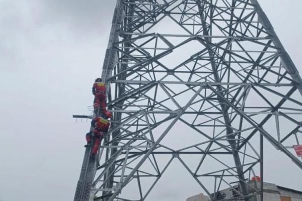 Petugas memanjat menara SUTET di kawasan Koja Jakarta Utara untuk mengevakuasi pemuda yang memanjat menara tersebut (Foto: Gulkarmat via ANTARA) 