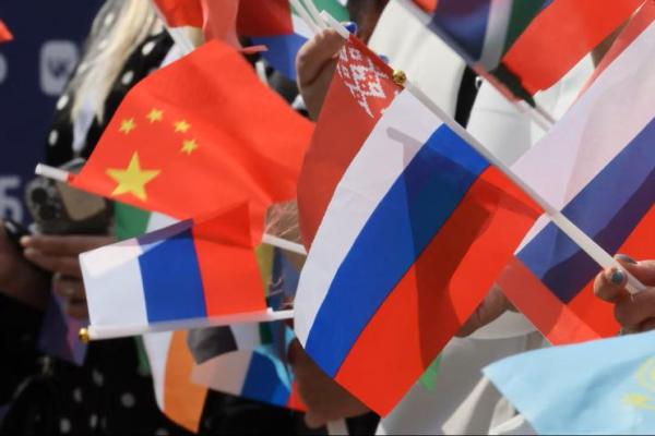 Para penonton mengibarkan bendera Rusia, Tiongkok, dan negara-negara lain pada acara hitung mundur 100 hari menuju Kontes Lagu Intervision di pusat kota Moskow, Rusia, pada 12 Juni 2025. REUTERS 