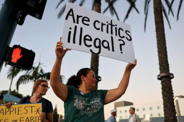 Orang-orang memegang spanduk selama protes di luar Disneyland, setelah acara bincang-bincang larut malam Jimmy Kimmel ditangguhkan, di Anaheim, California, AS, 19 September 2025. REUTERS 