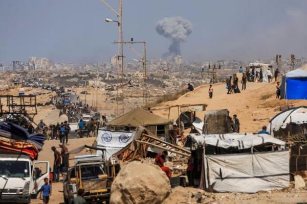 Asap mengepul dari serangan Israel, ketika warga Palestina yang terusir bergerak ke selatan untuk mengungsi, di Jalur Gaza tengah, 22 September 2025. REUTERS 