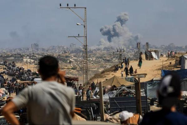 Asap mengepul dari serangan Israel, sementara warga Palestina yang mengungsi dari Gaza utara akibat operasi militer Israel, di Jalur Gaza tengah, 24 September 2025. REUTERS 