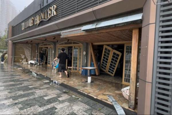Orang-orang berjalan di luar restoran yang rusak akibat Topan Super Ragasa di Hong Kong, Tiongkok, 24 September 2025. HO WA WONG via REUTERS 
