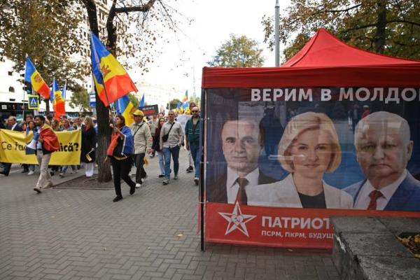 Pendukung Partai Aksi dan Solidaritas Moldova yang pro-Eropa berbaris melewati tenda kampanye Blok Elektoral Patriotik dalam sebuah demonstrasi menjelang pemilihan parlemen mendatang di Chisinau, Moldova, 26 September 2025. REUTERS 