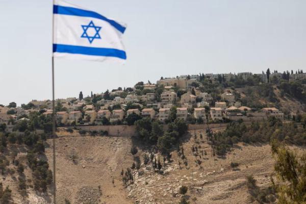 Bendera Israel berkibar, sementara sebagian permukiman Israel di Maale Adumim terlihat di latar belakang, di Tepi Barat yang diduduki Israel, 14 Agustus 2025. REUTERS 