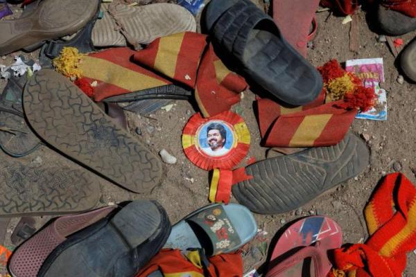 Sebuah lencana bergambar Vijay, aktor dan politisi, tergeletak di antara alas kaki dan barang-barang lain yang ditinggalkan oleh para peserta di lokasi insiden desak-desakan selama rapat umum kampanye pemilu yang diadakan oleh partai Tamilaga Vettri Kazhagam, di distrik Karur, Tamil Nadu, India, 28 September 2025. REUTERS 