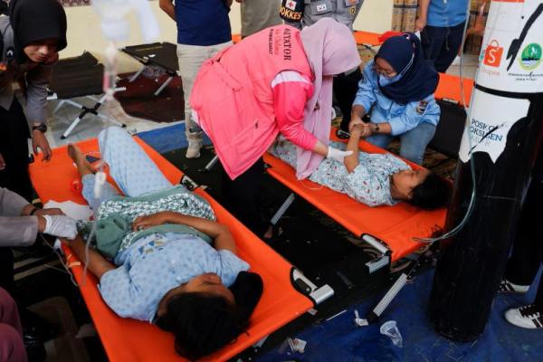 Para siswa menerima perawatan keracunan makanan setelah mengonsumsi makanan sekolah gratis yang disponsori pemerintah, di sebuah klinik darurat di dalam aula sebuah kabupaten di Bandung, Provinsi Jawa Barat, Indonesia, 25 September 2025. REUTERS 