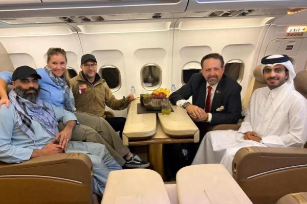 Amir Amiri, yang telah ditahan di Afghanistan sejak Desember 2024, berpose untuk foto bersama Adam Boehler, utusan khusus AS untuk tanggap penyanderaan, Sebastian Gorka, wakil asisten presiden AS dan direktur senior kontraterorisme, dan seorang diplomat Qatar, di dalam pesawat dari Kabul, Afghanistan, 28 September 2025. Handout via REUTERS 