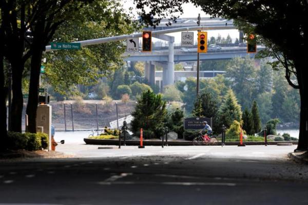 Pengendara sepeda dan pelari melintasi Taman Waterfront di Portland, Oregon, sehari setelah Presiden AS Donald Trump memerintahkan militer AS untuk dikerahkan ke kota tersebut, AS, 28 September 2025. REUTERS 