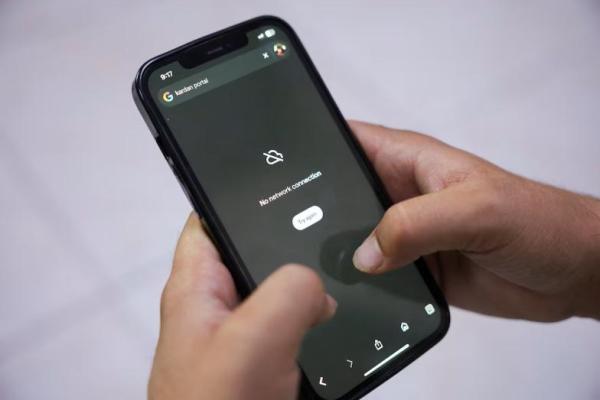 Seorang pria mencoba menggunakan Google di ponsel pintarnya di tengah pemutusan total telekomunikasi di seluruh negeri, di Kabul, Afghanistan, 30 September 2025. REUTERS 