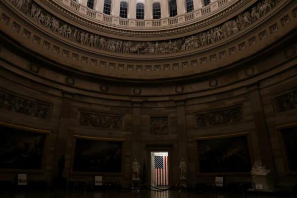 Bendera AS dikibarkan di pintu masuk rotunda yang kosong di Gedung Capitol AS beberapa jam sebelum penutupan sebagian pemerintah di Washington, AS, 30 September 2025. REUTERS 