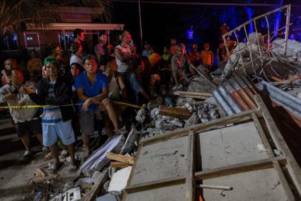 Warga menyaksikan tim penyelamat mengevakuasi jenazah korban yang ditemukan di bawah reruntuhan rumah akibat gempa berkekuatan 6,9 skala Richter di Bogo, Cebu, Filipina, 1 Oktober 2025. REUTERS 