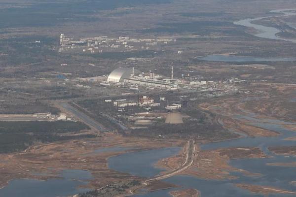 Pemandangan udara dari pesawat menunjukkan struktur New Safe Confinement di atas sarkofagus tua yang menutupi reaktor keempat yang rusak di PLTN Chernobyl, Ukraina, 3 April 2021. REUTERS 
