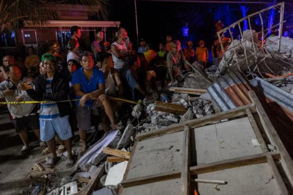 Warga menyaksikan tim penyelamat mengevakuasi jenazah korban yang ditemukan di bawah reruntuhan rumah akibat gempa berkekuatan 6,9 skala Richter di Bogo, Cebu, Filipina, 1 Oktober 2025. REUTERS 