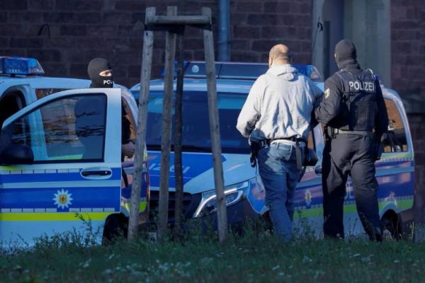 Salah satu tersangka agen asing Hamas, yang diyakini mempersiapkan tindakan kekerasan serius yang menargetkan institusi Israel atau Yahudi di Jerman, dikawal oleh polisi saat tiba di Kantor Kejaksaan Umum Federal Jerman di Karlsruhe, Jerman, 2 Oktober 2025. REUTERS 