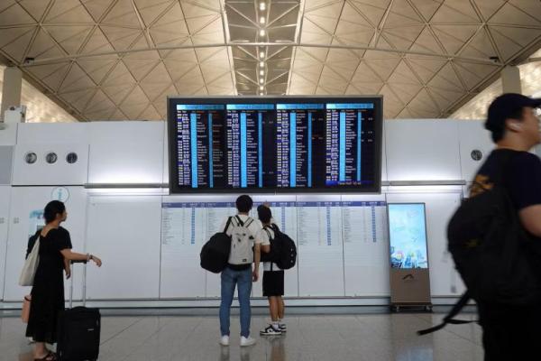 Penumpang memeriksa layar informasi penerbangan di Bandara Internasional Hong Kong di Hong Kong, Tiongkok, 16 Juni 2025. REUTERS 