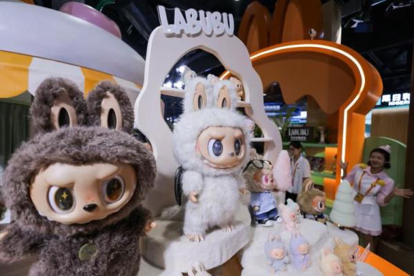 Seorang karyawan menunjuk di samping mainan Labubu yang dipajang di stan Pop Mart pada Pameran Perdagangan Jasa Internasional Tiongkok di Beijing, Tiongkok, 10 September 2025. REUTERS 