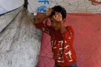 Seorang anak Palestina yang mengungsi akibat operasi militer Israel, berdiri di dekat pagar, sambil beristirahat di pinggir jalan, di Jalur Gaza tengah, 5 Oktober 2025. REUTERS