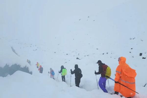 Tangkapan layar dari video menunjukkan para pendaki meninggalkan perkemahan mereka, di tengah hujan salju lebat yang tak biasa mengguyur Himalaya, di wilayah Tibet, Tiongkok, pada hari Minggu (5/10/2025). (FOTO: REUTERS) 