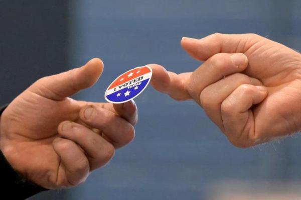 Seorang pemilih menerima stiker setelah memberikan suaranya di New Begin Hall selama pemilihan presiden AS 2024 pada Hari Pemilihan di Gray, Maine, AS, 5 November 2024. REUTERS 