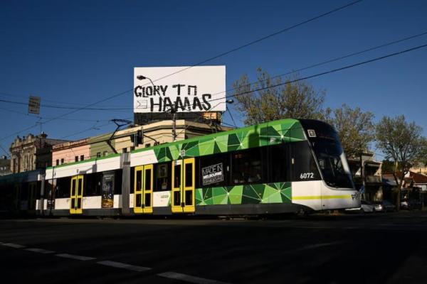 Grafiti bertuliskan Glory to Hamas terlihat di papan reklame di atas sebuah toko di Melbourne, Australia, 7 Oktober 2025. Foto: AAP 