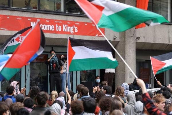 Para pengunjuk rasa mengibarkan bendera saat mahasiswa berpartisipasi dalam pawai antar-universitas untuk mendukung warga Palestina, di kampus Kings College London, Inggris, 7 Oktober 2025. REUTERS 