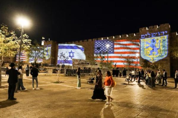Bendera Amerika Serikat dan Israel diproyeksikan di dinding Kota Tua Yerusalem dalam perayaan setelah Israel dan Hamas menyetujui tahap pertama rencana Presiden AS Donald Trump untuk mengakhiri perang di Gaza, 9 Oktober 2025. REUTERS 