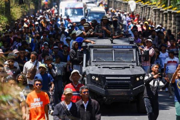 Para pengunjuk rasa berbaris di samping kendaraan militer Madagaskar selama protes nasional yang dipimpin pemuda atas seringnya pemadaman listrik dan kekurangan air, di Antananarivo, Madagaskar, 13 Oktober 2025. REUTERS 
