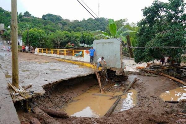 Sejumlah pria berdiri di dekat jembatan yang rusak di Jalcocotan, negara bagian Nayarit, Meksiko. REUTERS 