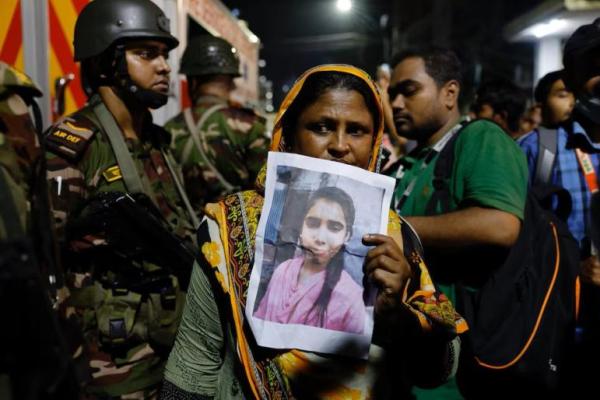Seorang kerabat berduka sambil memegang foto seorang gadis yang hilang setelah kebakaran yang terjadi di sebuah pabrik garmen dan gudang bahan kimia di Dhaka, Bangladesh, 14 Oktober 2025. REUTERS 
