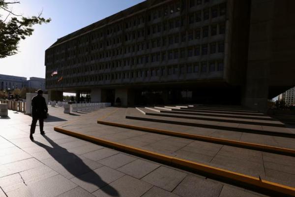 Seorang pria membentuk bayangan saat berjalan menuju Gedung Hubert H. Humphrey, kantor pusat Departemen Kesehatan dan Layanan Kemanusiaan, di Washington, AS, 1 April 2025. REUTERS 
