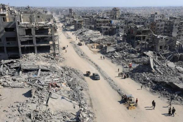 Warga Palestina berjalan melewati reruntuhan bangunan yang hancur, di tengah gencatan senjata antara Israel dan Hamas, di Kota Gaza, 16 Oktober 2025. REUTERS 