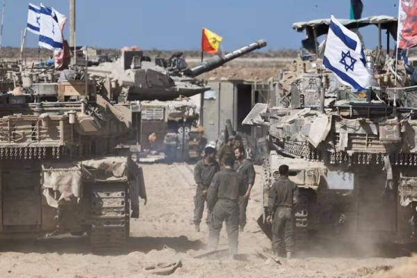 Tentara Israel berdiri di samping tank-tank di dekat perbatasan Israel-Gaza, di Israel, 19 Oktober 2025. REUTERS 