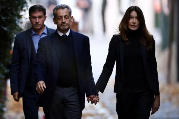Mantan Presiden Prancis Nicolas Sarkozy meninggalkan rumahnya bersama istrinya, Carla Bruni-Sarkozy, pada hari penahanannya di penjara Sante, di Paris, Prancis, 21 Oktober 2025. REUTERS 