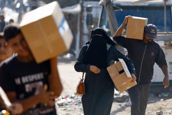 Warga Palestina membawa pasokan bantuan yang masuk ke Gaza, di tengah gencatan senjata antara Israel dan Hamas di Gaza, di Zawaida, Jalur Gaza tengah, 21 Oktober 2025. REUTERS 