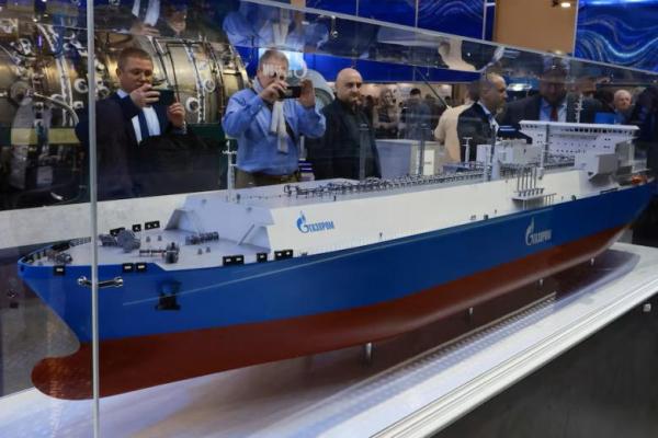 Orang-orang mengambil foto model kapal pengangkut LNG berlogo Gazprom di forum gas internasional Saint Petersburg di Saint Petersburg, Rusia, 8 Oktober 2025. REUTERS 