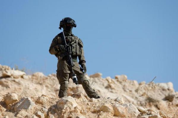 Seorang anggota pasukan Israel berjaga-jaga saat pasukan Israel memblokir akses warga Palestina dan aktivis asing ke pohon zaitun selama panen zaitun, dekat Hebron, di Tepi Barat yang diduduki Israel, 23 Oktober 2025. REUTERS 