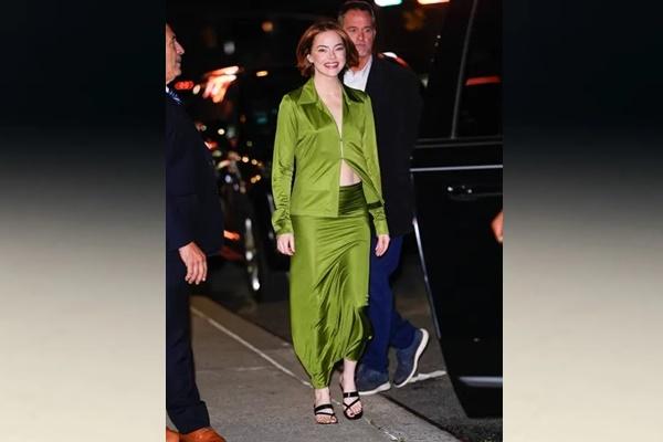 Emma Stone tersenyum sambil berjalan mengenakan atasan satin hijau cerah dan rok panjang yang serasi karya Donna Karan langsung dikenali oleh penggemar film Great Expectations tahun 1998. (FOTO: GC IMAGE) 