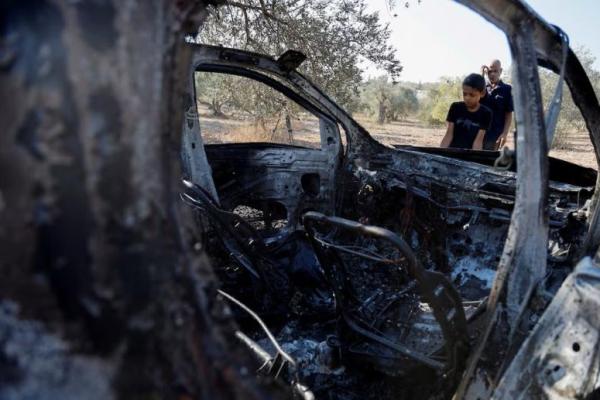 Orang-orang memeriksa kendaraan yang terbakar di lokasi tempat pasukan Israel membunuh tiga warga Palestina, dekat Jenin, di Tepi Barat yang diduduki Israel, 28 Oktober 2025. REUTERS 
