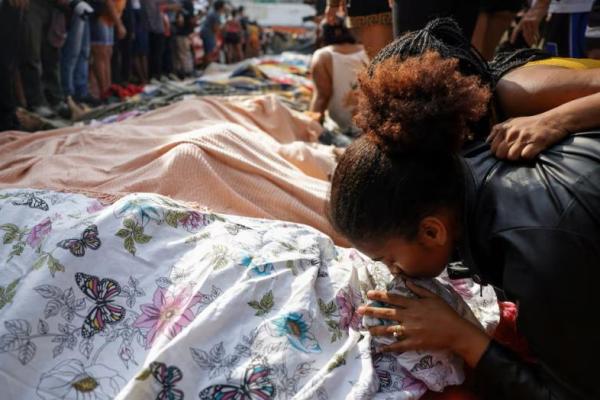 Seorang pelayat mencium jenazah yang ditutupi, sehari setelah operasi polisi yang mematikan di Rio de Janeiro. REUTERS 