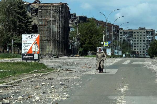 Seorang warga berjalan di jalan dekat gedung-gedung yang rusak akibat serangan militer Rusia, di kota garis depan Pokrovsk, wilayah Donetsk, Ukraina, 21 Mei 2025. REUTERS 