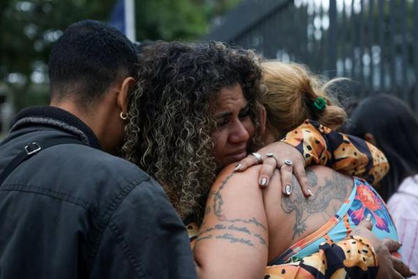 Orang-orang berpelukan di luar kamar mayat, sementara keluarga korban menunggu untuk mengidentifikasi jenazah setelah operasi mematikan polisi terhadap perdagangan narkoba di favela do Penha, Rio de Janeiro, Brasil, 30 Oktober 2025. REUTERS 