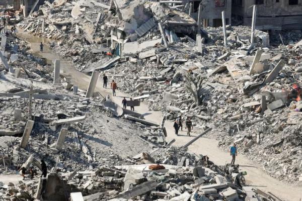 Warga Palestina berjalan melewati reruntuhan bangunan, di tengah gencatan senjata antara Israel dan Hamas, di Kota Gaza, 2 November 2025. REUTERS 